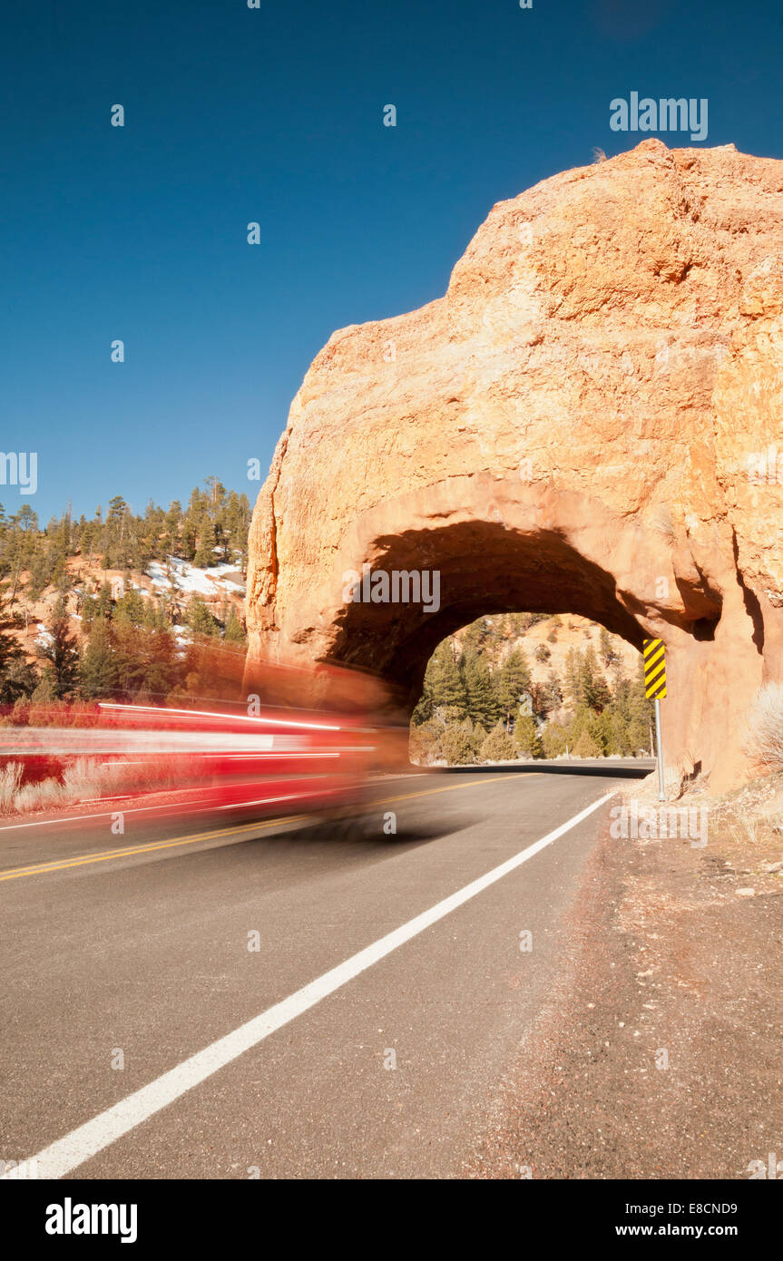 Flou de mouvement d'un véhicule avec de la pierre naturelle arch, Red Canyon, Dixie National Forest, Scenic Byway 12, Utah, United States Banque D'Images