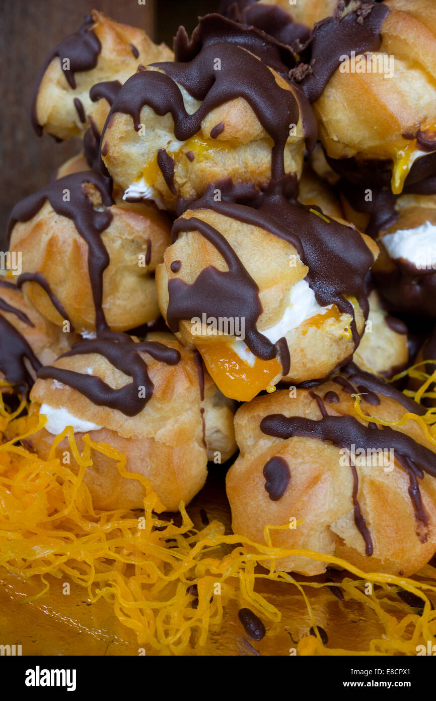 Gros plan des couverts dans le chocolat profiteroles Banque D'Images