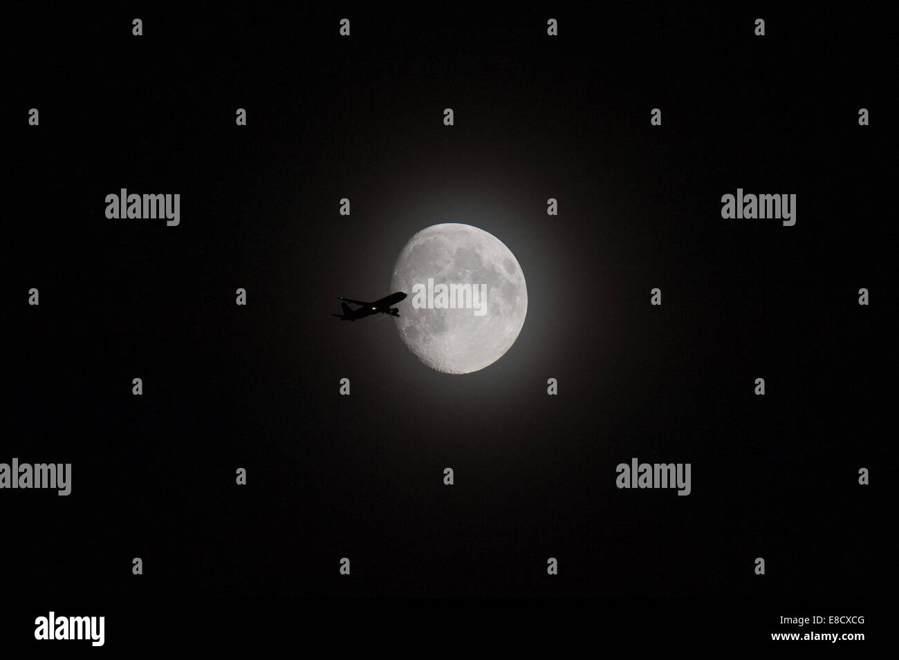 Angleterre, Royaume-Uni. 5 octobre, 2014. L'un d'une séquence de photos capturés par hasard en photographiant la lune sur le sud de l'Angleterre dans la soirée du 5 octobre 2014. En raison de l'orientation de la lune à l'époque, l'avion était probablement au départ de l'aéroport de Heathrow. Il ressemble à un Airbus d'une certaine sorte. Crédit : Gary Eason/Alamy Live News Banque D'Images