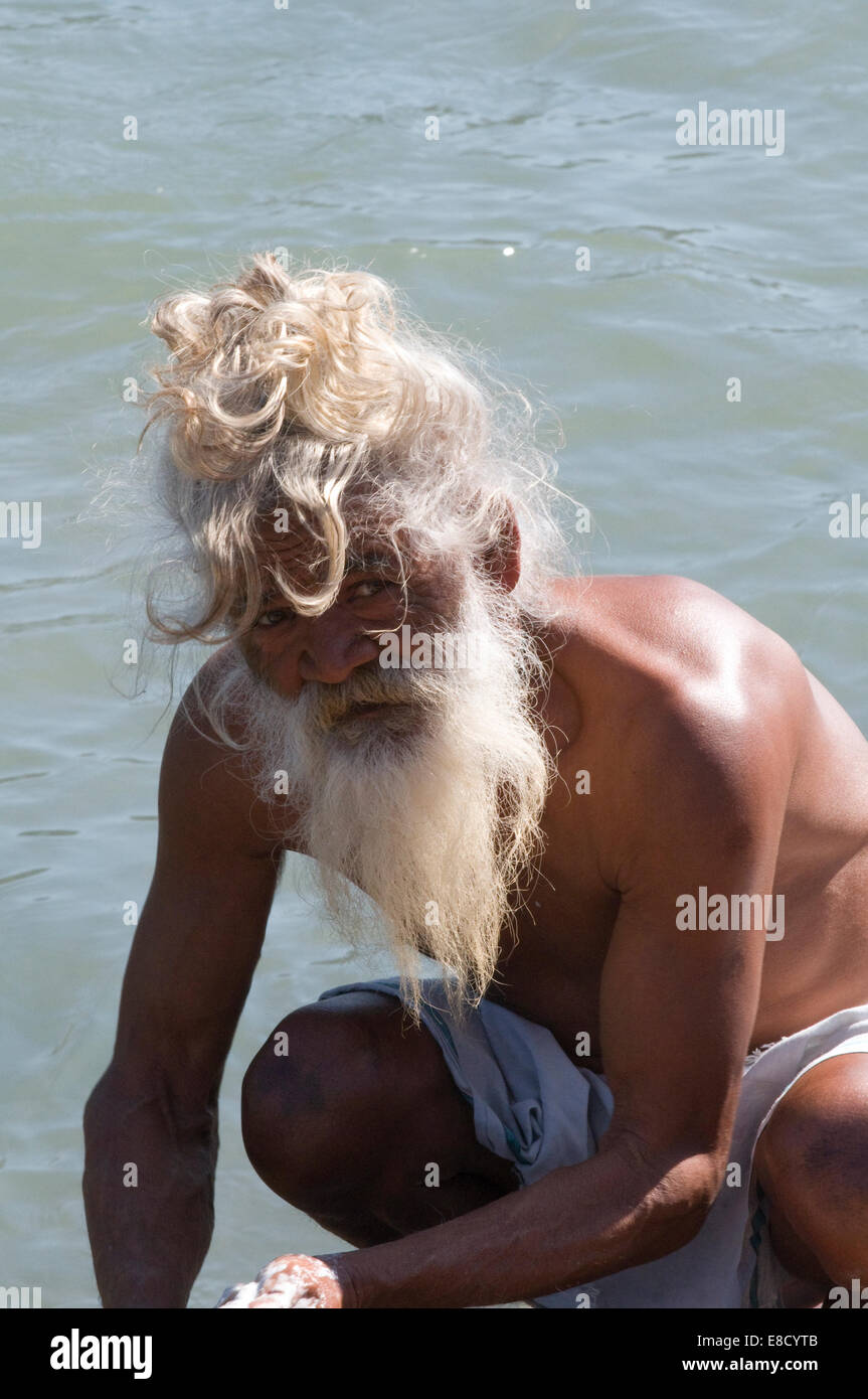 Sadhu barbu aux cheveux blancs et à laver les vêtements dans le Gange Rishikesh au nord de l'Inde Uttarakanth Banque D'Images
