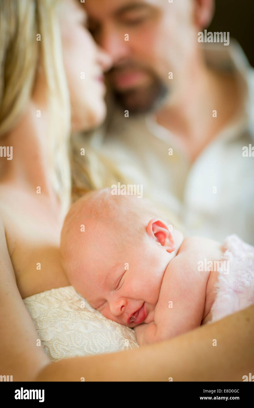 Belle Young Couple Holding Leur Nouveau Ne Bebe Fille Dormir A L Interieur Photo Stock Alamy