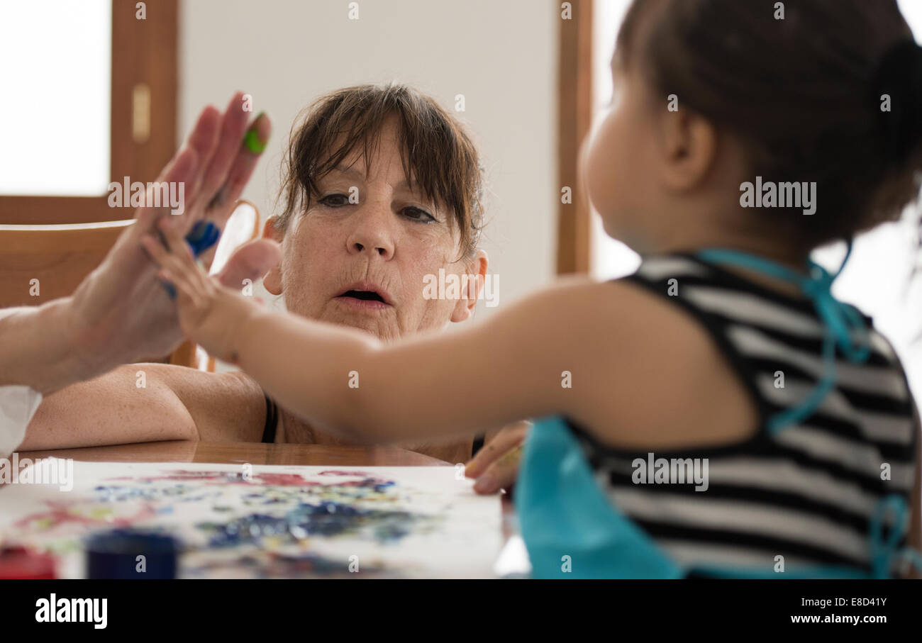 Grand-mère la peinture au doigt avec petit-enfant Banque D'Images