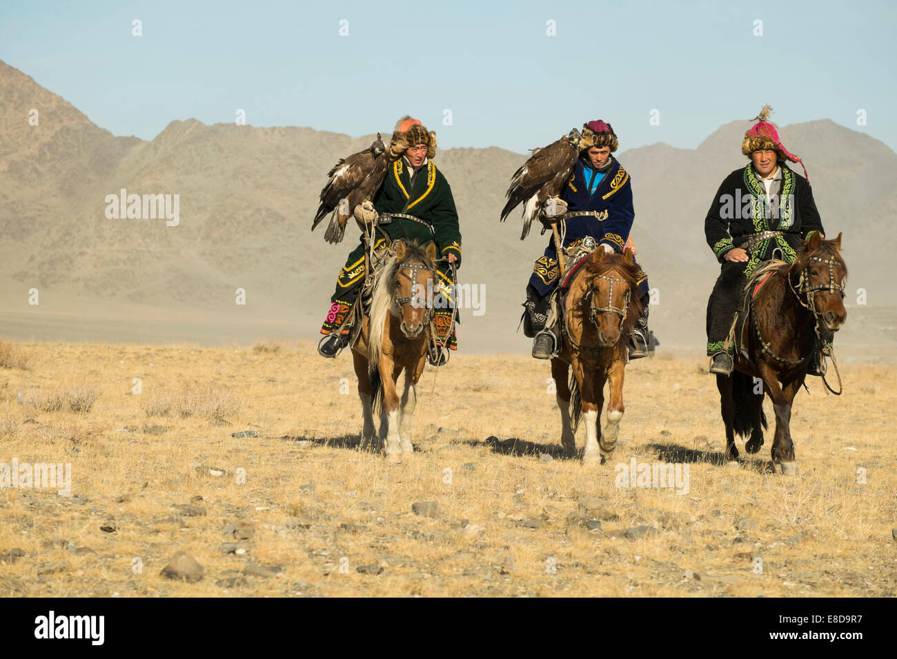 Trois chasseurs eagle kazakhs sur leurs chevaux sur le chemin de l'Aigle Festival à Sagsai, Bayan-Oelgii, Mongolie Aimag Banque D'Images