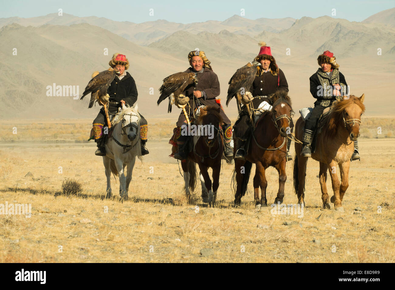 Quatre chasseurs eagle kazakhs sur leurs chevaux sur le chemin de l'Aigle Festival à Sagsai, Bayan-Oelgii, Mongolie Aimag Banque D'Images