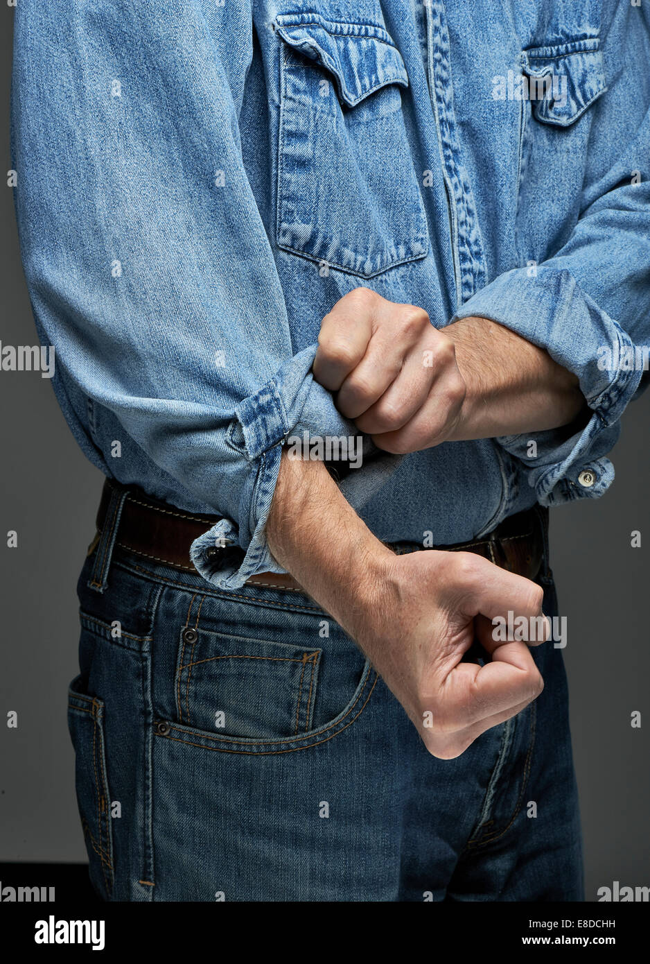 L'homme en chemise en jean retrousser ses manches Photo Stock - Alamy