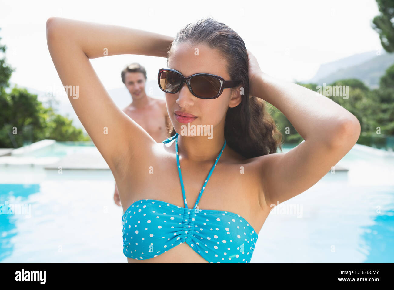 Belle femme par piscine sur une journée ensoleillée Banque D'Images