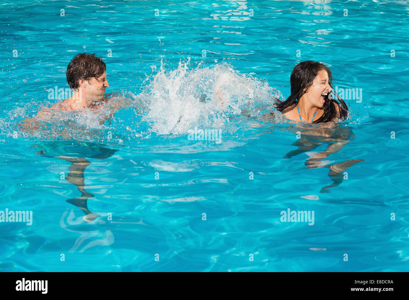 Couple playing in swimming pool Banque D'Images
