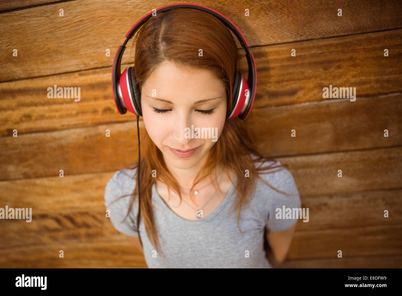 Rousse pacifiques d'écouter de la musique avec les yeux fermés Banque D'Images