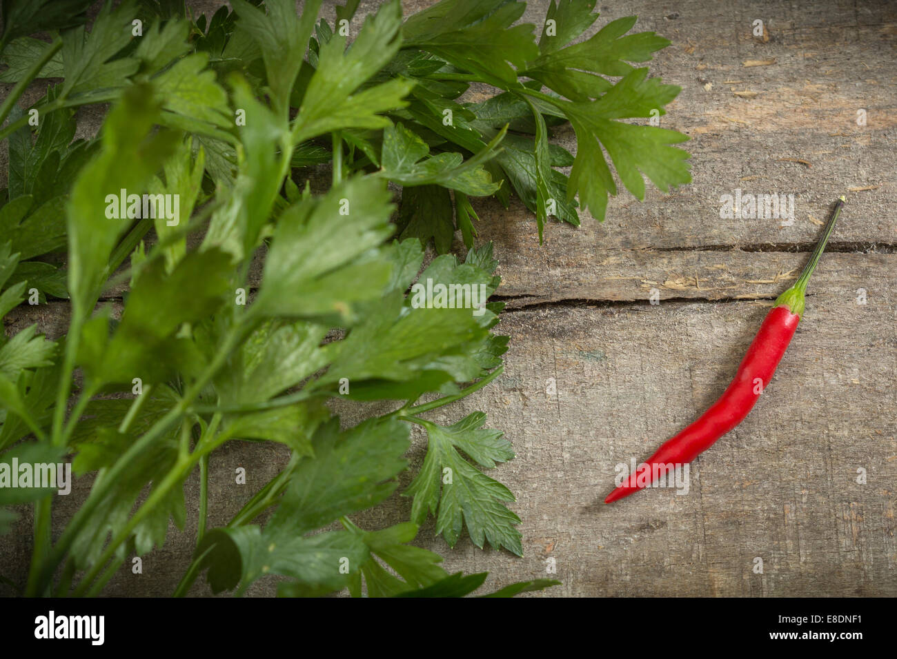 Piment rouge et le persil sur fond de bois Banque D'Images