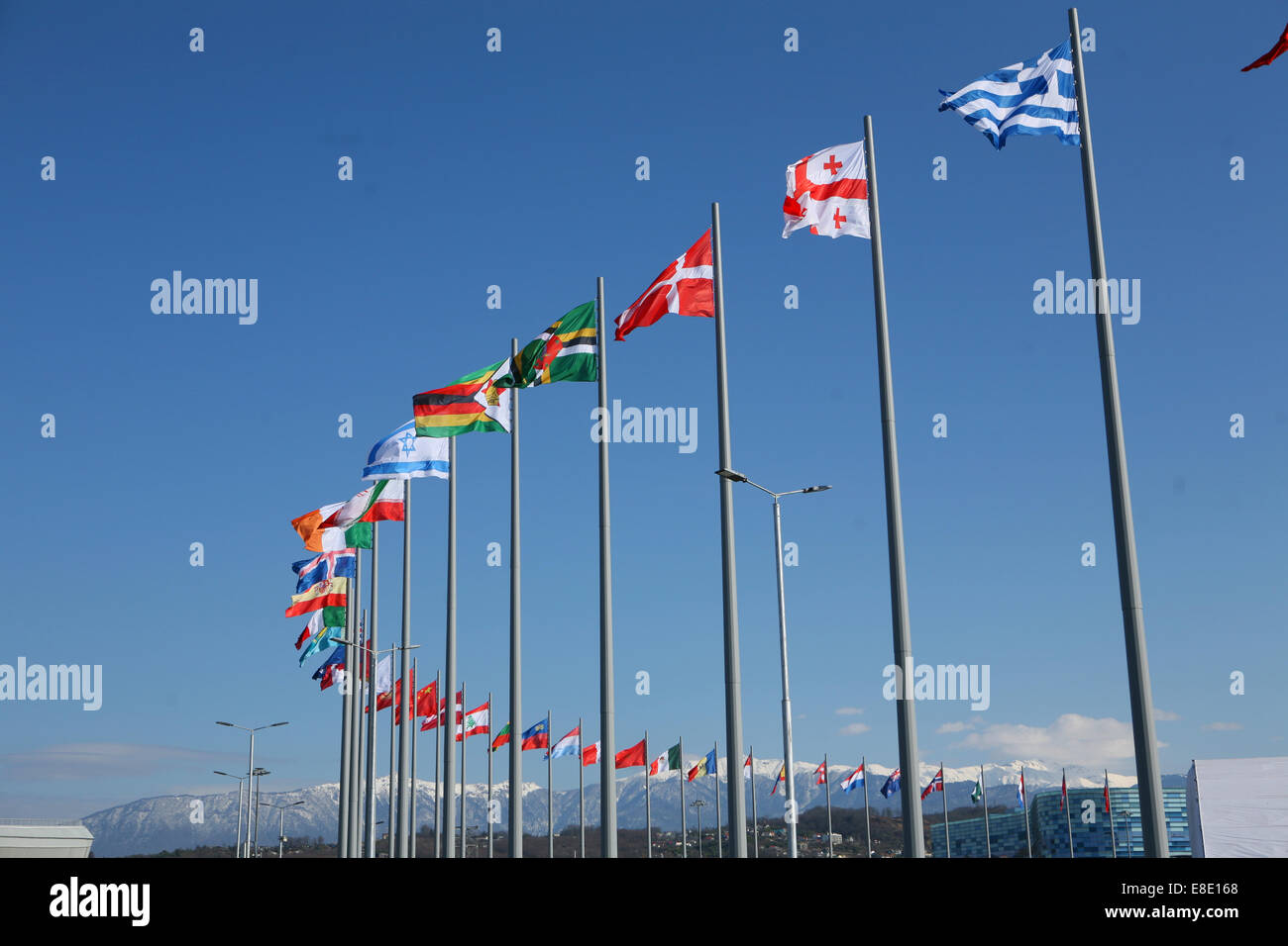 Courbe des drapeaux internationaux montagnes en arrière-plan Sotchi Banque D'Images