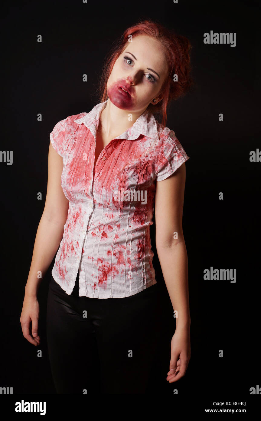 Zombie femelle avec bouche sanglante et un chemisier sur fond noir Banque D'Images