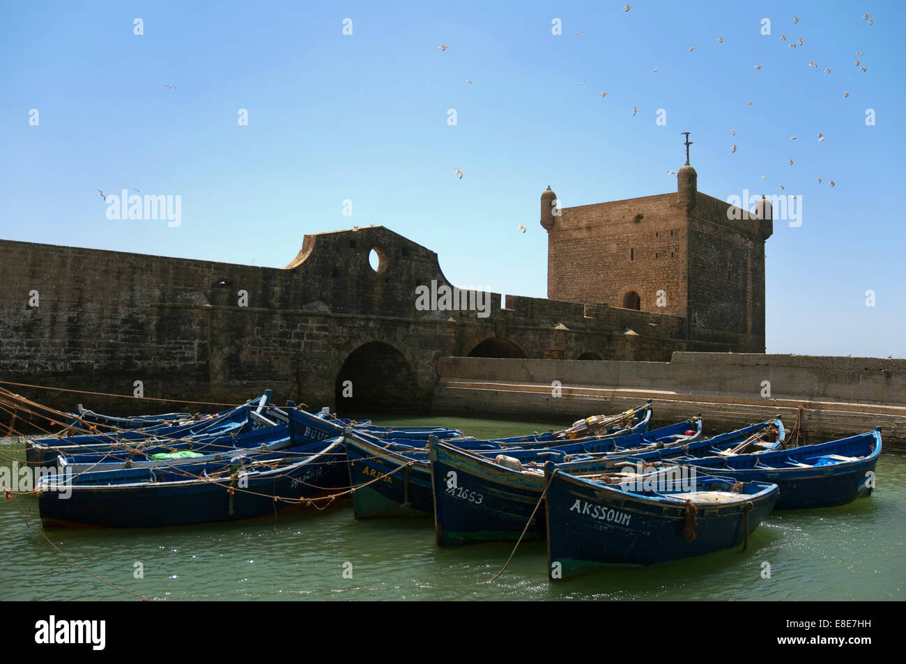 Vue horizontale de la forteresse à Essaouira avec des bateaux de pêche sur une journée ensoleillée. Banque D'Images