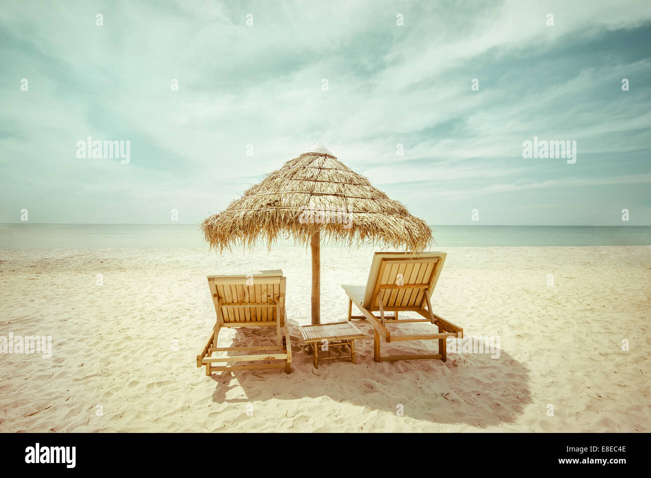 Plage tropicale extraordinaire paysage avec parapluie de chaume et des chaises pour se détendre sur le sable. En arrière-plan de voyage style vintage Banque D'Images