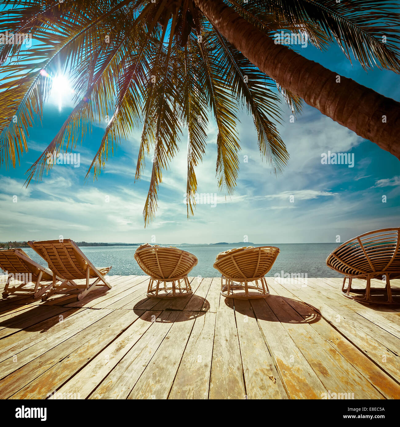 Paysage incroyable plage tropicale avec palmiers et des chaises pour se détendre sur la terrasse en bois. En arrière-plan de voyage style vintage Banque D'Images