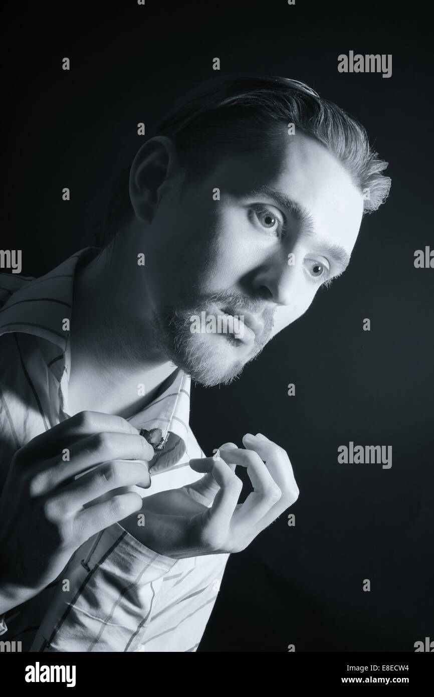 Portrait d'un jeune homme séduisant sur fond noir Banque D'Images