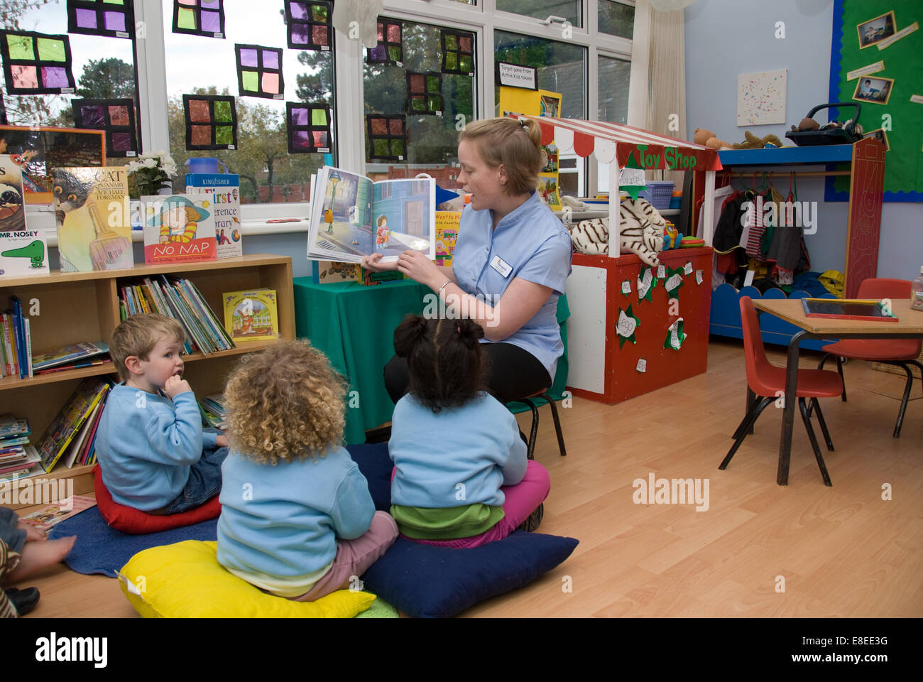 Lire une histoire de l'enseignant pour 3 élèves de maternelle Banque D'Images