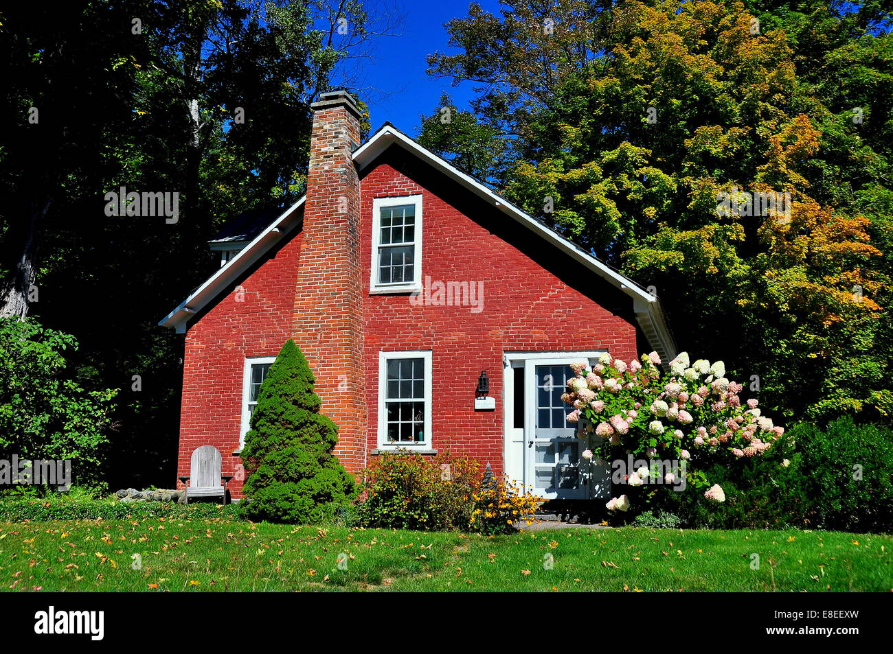 Grafton, New York : un petit cottage en brique du xixe siècle avec l'Hydrangea Flowers à côté de la porte * Banque D'Images