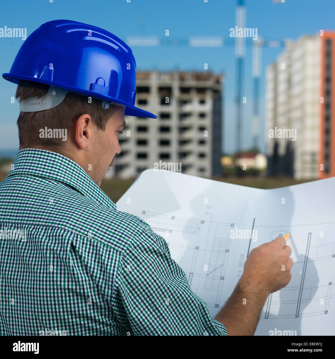 Vue de dos, libre d'hommes au travail Ingénieur du Caucase à la technique au plan de dessin Banque D'Images Vue de dos, libre d'hommes au travail Ingénieur du Caucase à la technique au plan de dessin Banque D'Images