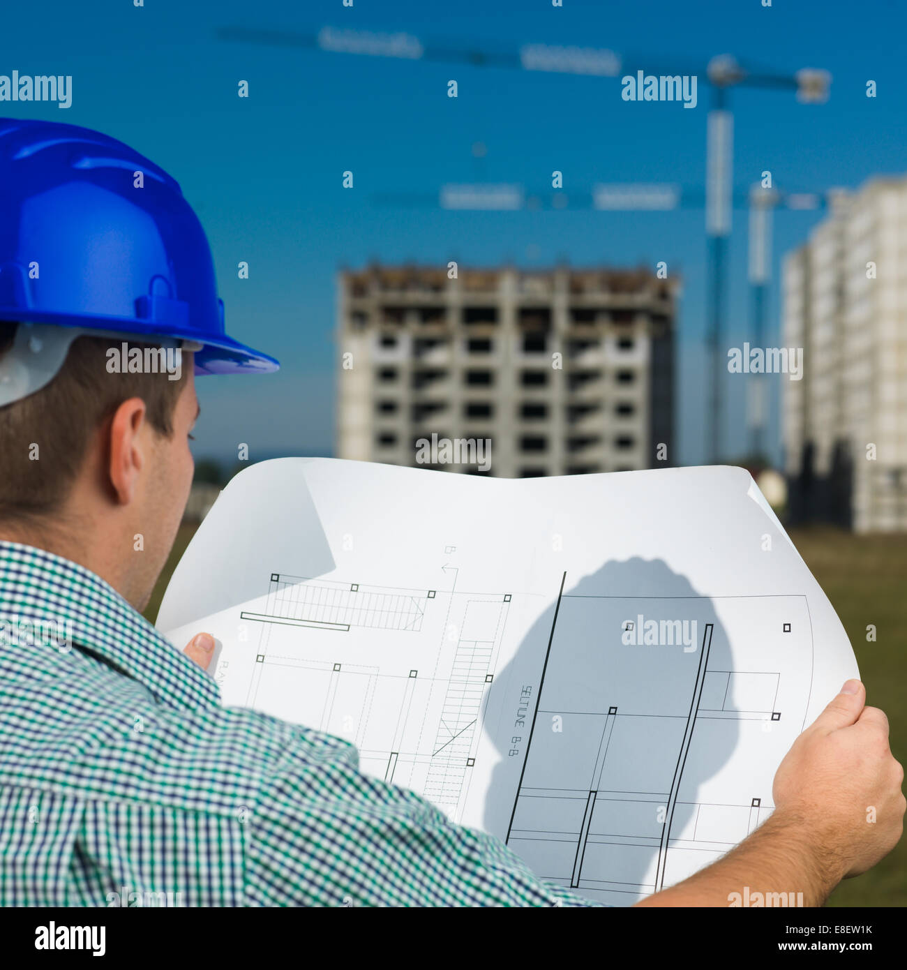 Vue de dos, libre d'hommes au travail Ingénieur du Caucase à la technique au plan de dessin Banque D'Images Vue de dos, libre d'hommes au travail Ingénieur du Caucase à la technique au plan de dessin Banque D'Images