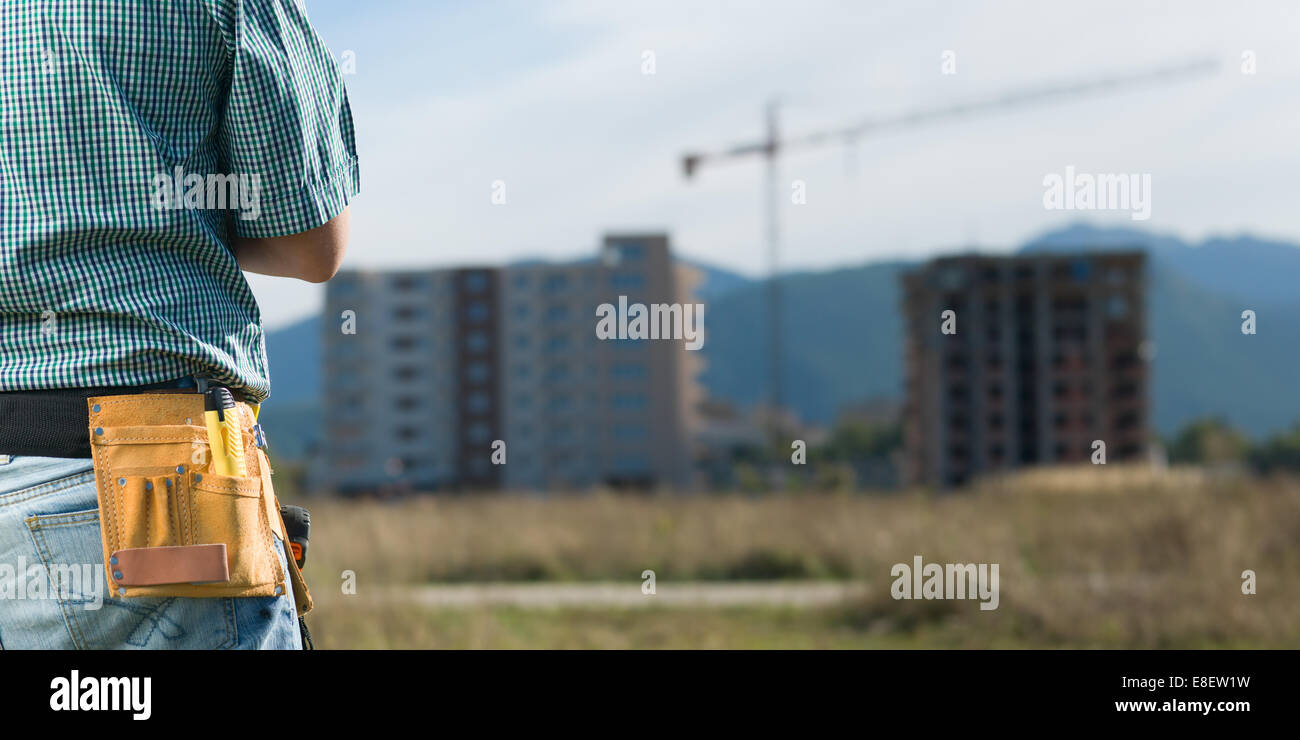 Gros plan, vue arrière de l'homme permanent ingénieur en bâtiment en construction Banque D'Images Gros plan, vue arrière de l'homme permanent ingénieur en bâtiment en construction Banque D'Images