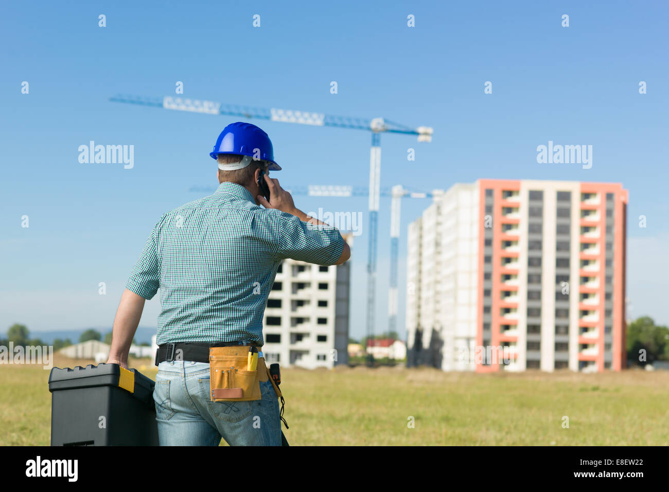 Vue arrière de l'caucasian enginner parlant au téléphone au site de construction résidentielle Banque D'Images Vue arrière de l'caucasian enginner parlant au téléphone au site de construction résidentielle Banque D'Images