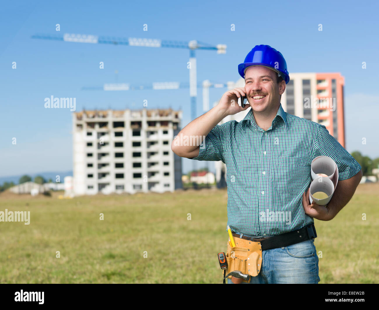 Portrait of happy ingénieur civil, parlant au téléphone, sur les plans d'exploitation construction site Banque D'Images Portrait of happy ingénieur civil, parlant au téléphone, sur les plans d'exploitation construction site Banque D'Images