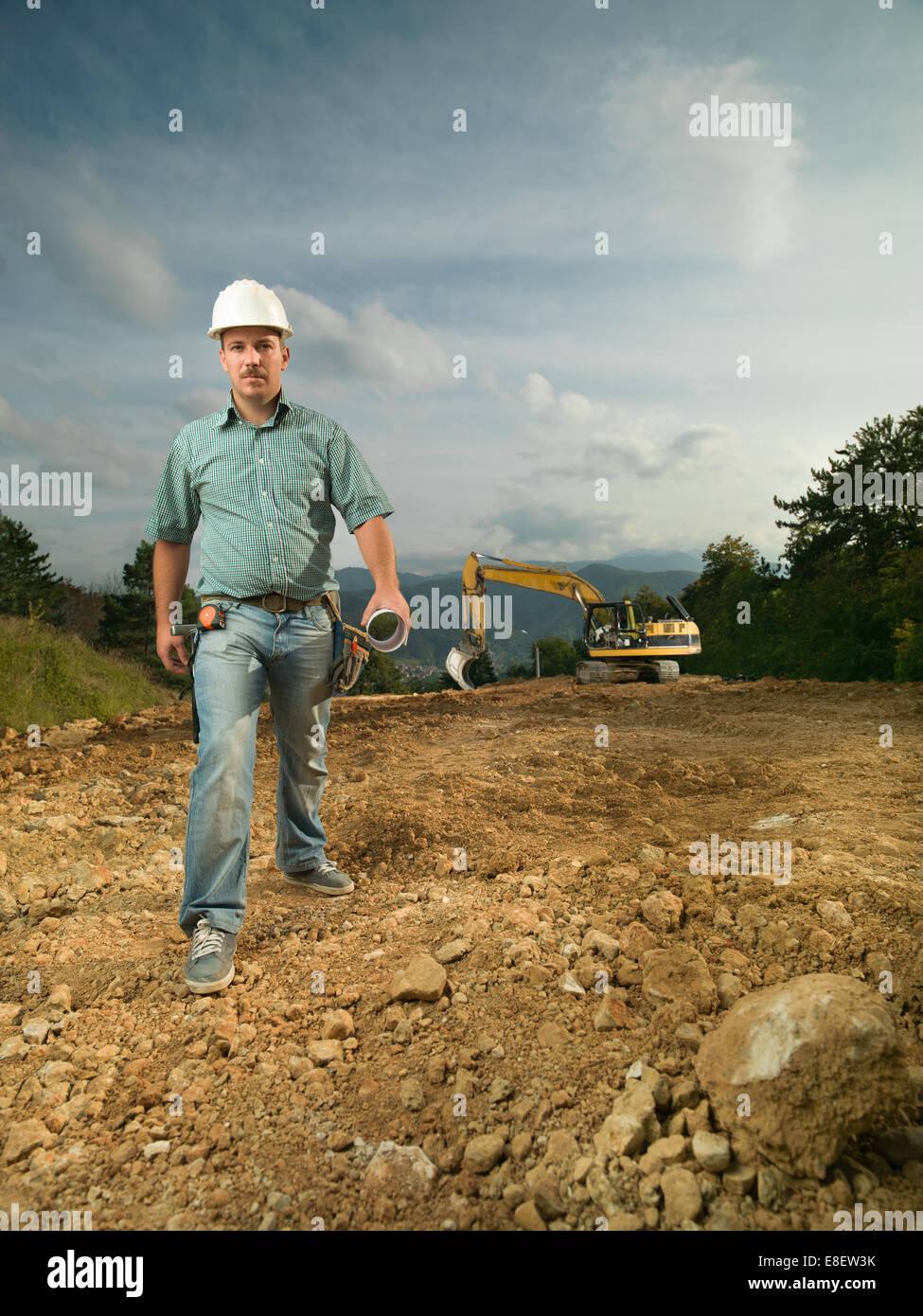Vue avant de handsome young engineer marche sur chantier Banque D'Images Vue avant de handsome young engineer marche sur chantier Banque D'Images