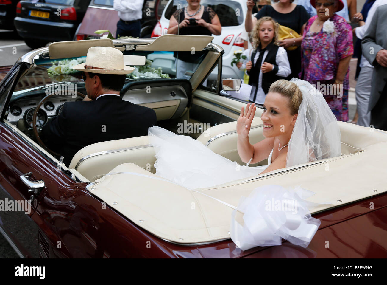 Mariée en Ford Mustang la saluant les invités au mariage Banque D'Images