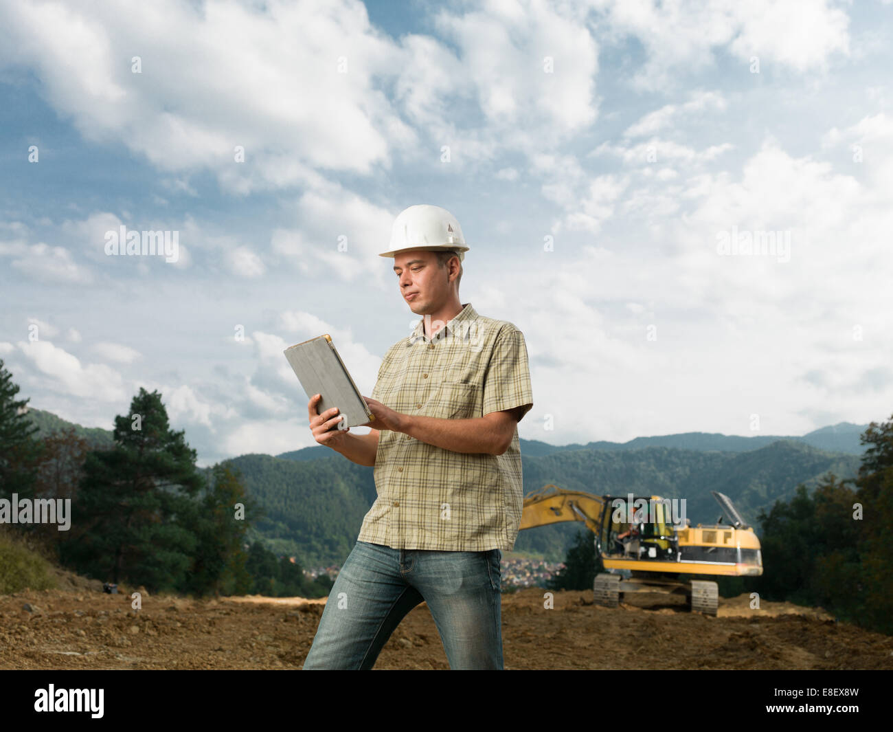 Portrait of young caucasian architect standing on construction site holding digital tablet Banque D'Images Portrait of young caucasian architect standing on construction site holding digital tablet Banque D'Images