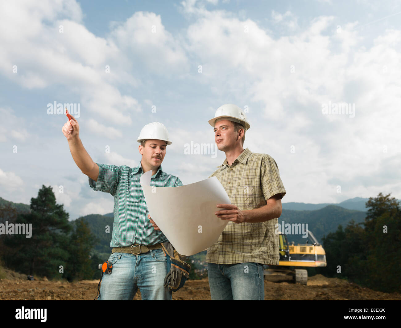 Deux beaux ingénieurs caucasienne comparant avec plan de construction réels Banque D'Images Deux beaux ingénieurs caucasienne comparant avec plan de construction réels Banque D'Images