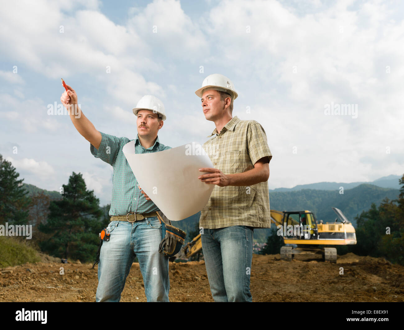 Deux beaux ingénieurs caucasienne comparant avec plan de construction réels Banque D'Images Deux beaux ingénieurs caucasienne comparant avec plan de construction réels Banque D'Images