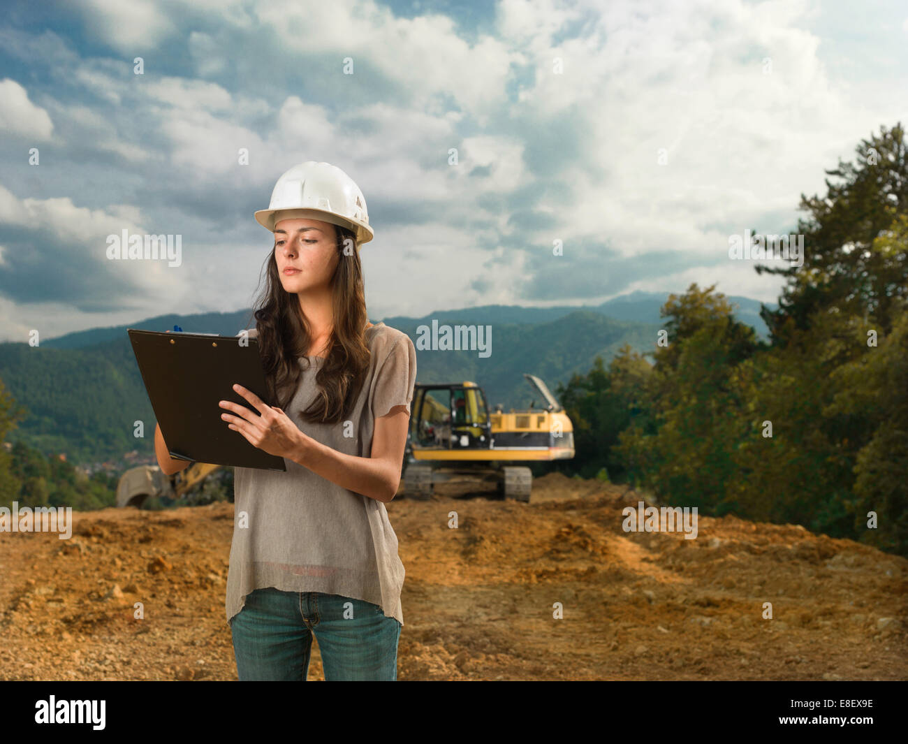 Portrait of young caucasian female architect at construction site, holding clipboard et écrit Banque D'Images Portrait of young caucasian female architect at construction site, holding clipboard et écrit Banque D'Images