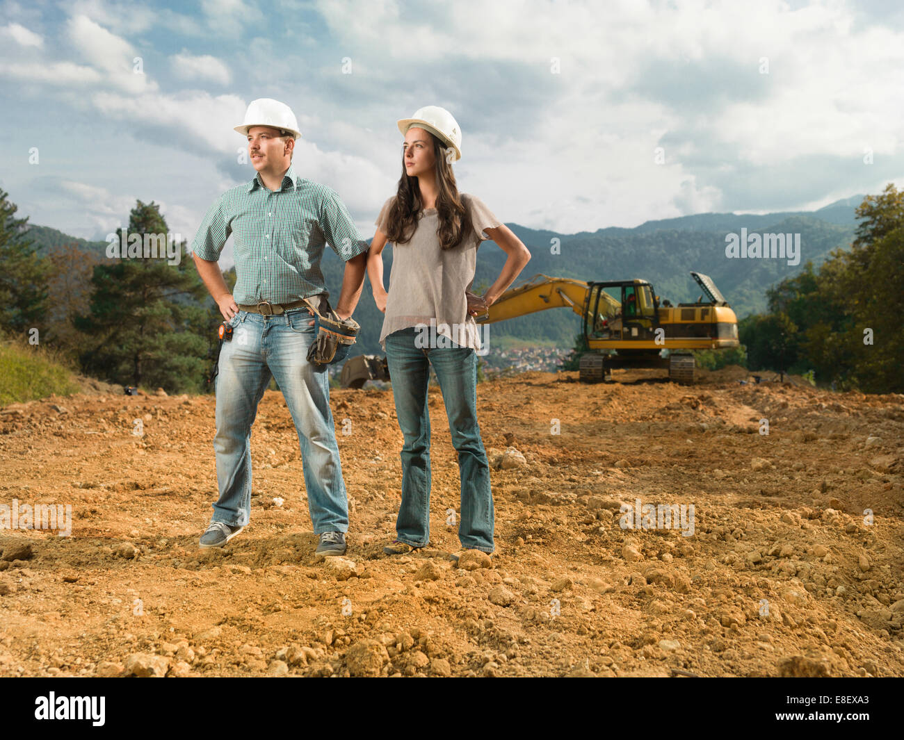 Les ingénieurs de collègues féminins et masculins debout sur le site de construction à l'écart Banque D'Images Les ingénieurs de collègues féminins et masculins debout sur le site de construction à l'écart Banque D'Images