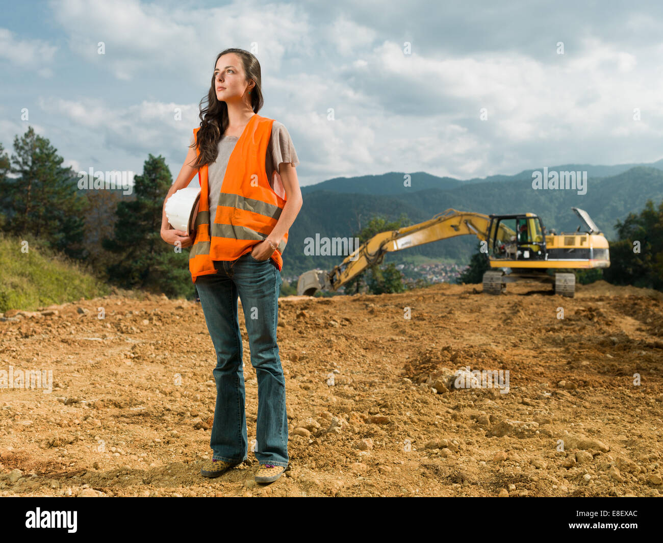 Travailleur de la construction ingénieur femelle sur site en plein air avec la pelle en arrière-plan Banque D'Images