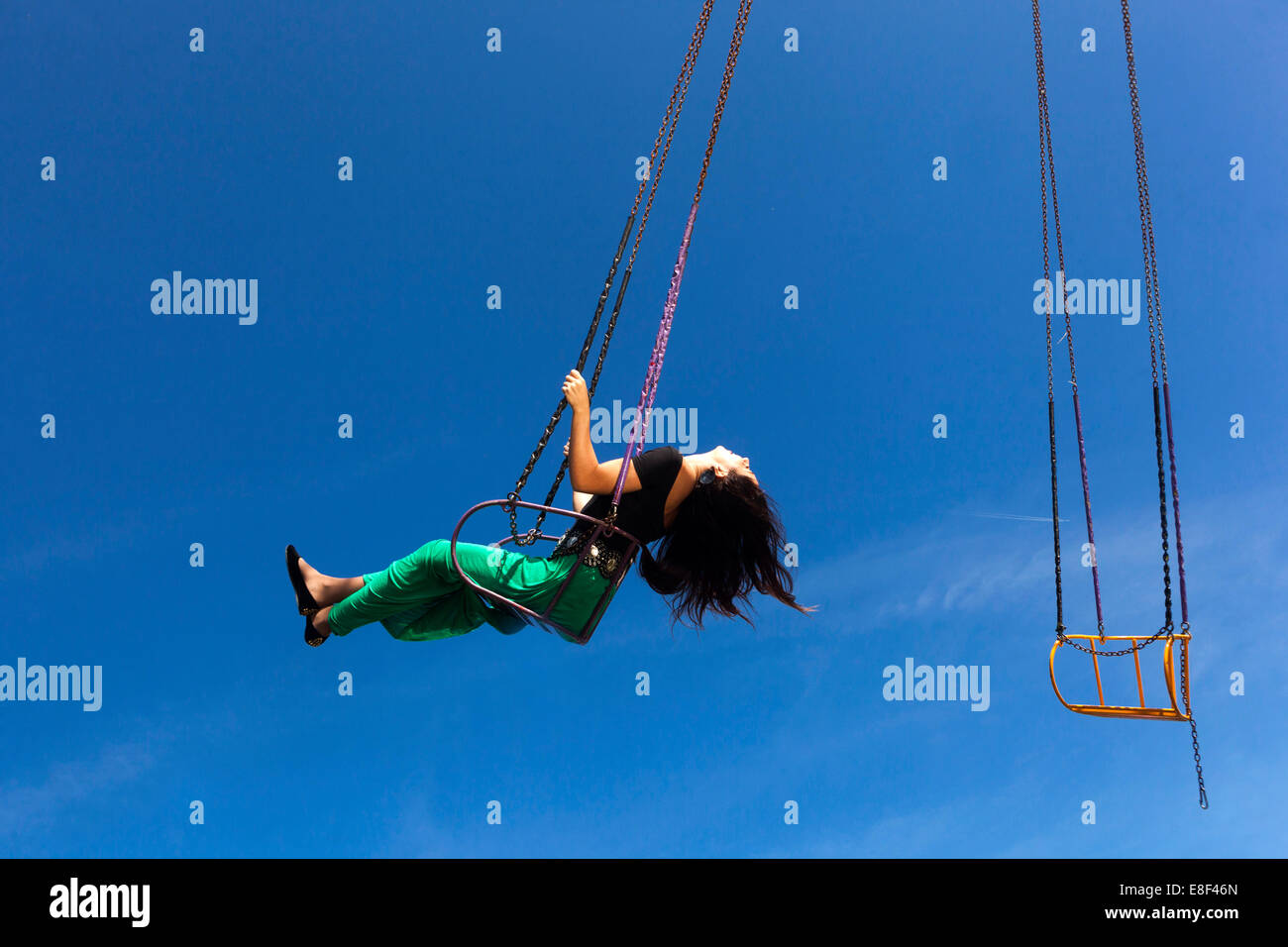 Une femme apprécie un tour de swing sur un carrousel Banque D'Images