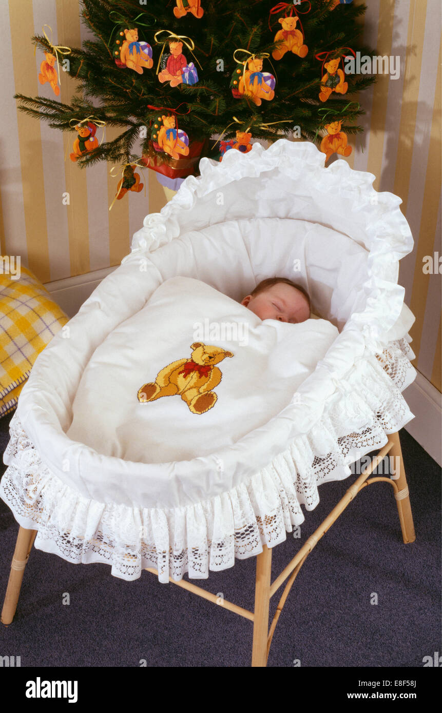 Bébé endormi dans un berceau garni de dentelle et coton blanc et avec de  croix ours quilt Photo Stock - Alamy