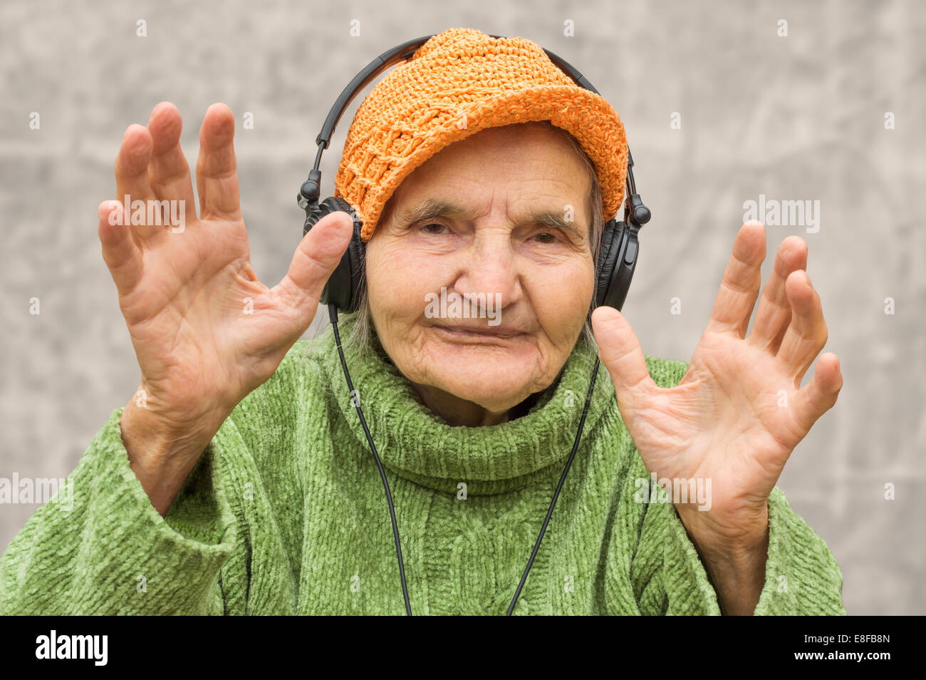 Femme âgée avec des écouteurs pour écouter de la musique. Banque D'Images