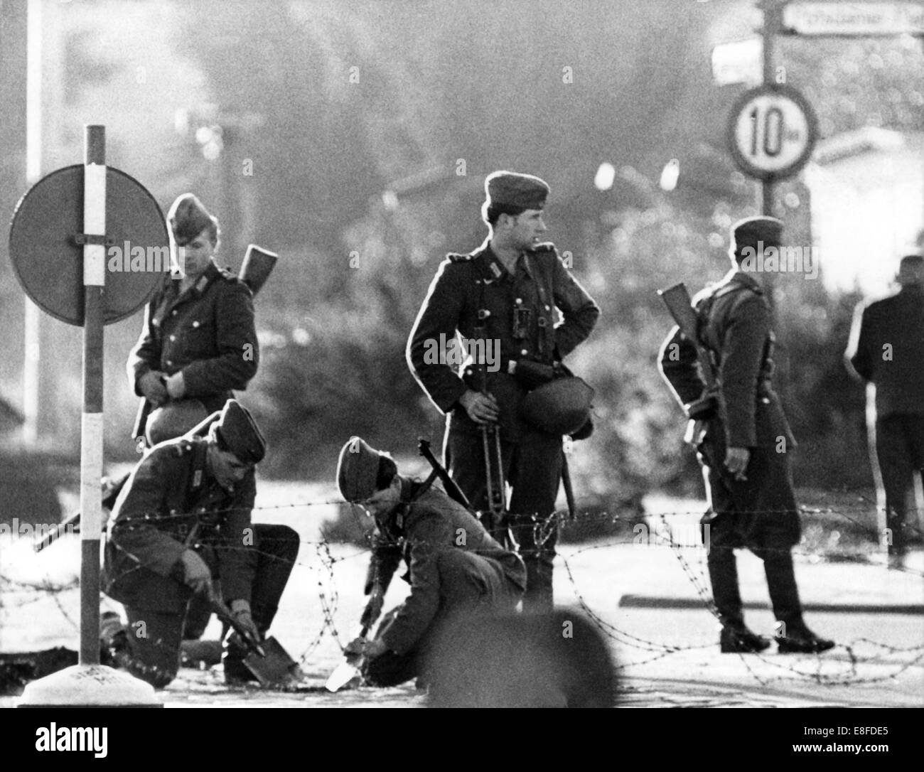 Les hommes de la police de la Police de la RDA la construction d'un fil de fer barbelé à la Place de Potsdam à Berlin le 14 août en 1961. Banque D'Images