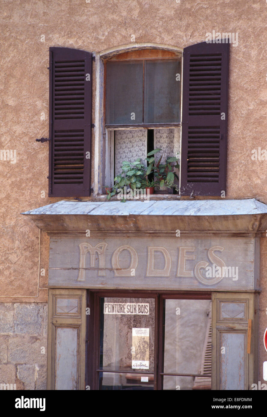 Volets noir sur la fenêtre au-dessus de vieux 'Modes' magasin de vêtements dans une petite ville française Banque D'Images