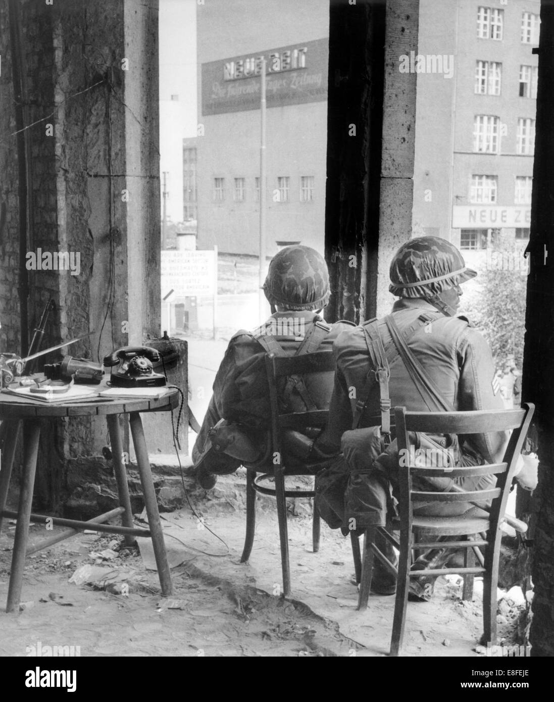 Des soldats de l'armée américaine assise dans une ruine sur Friedrichstrasse à Berlin Ouest et le maintien de la garde à la frontière du secteur à l'est de ville le 29 août 1961. Du 13 août 1961, le jour de la construction du mur, jusqu'à la chute du Mur de Berlin le 9 novembre 1989, la République fédérale d'Allemagne et la RDA ont été partagés par le "rideau de fer" entre l'Occident et l'orient. Banque D'Images