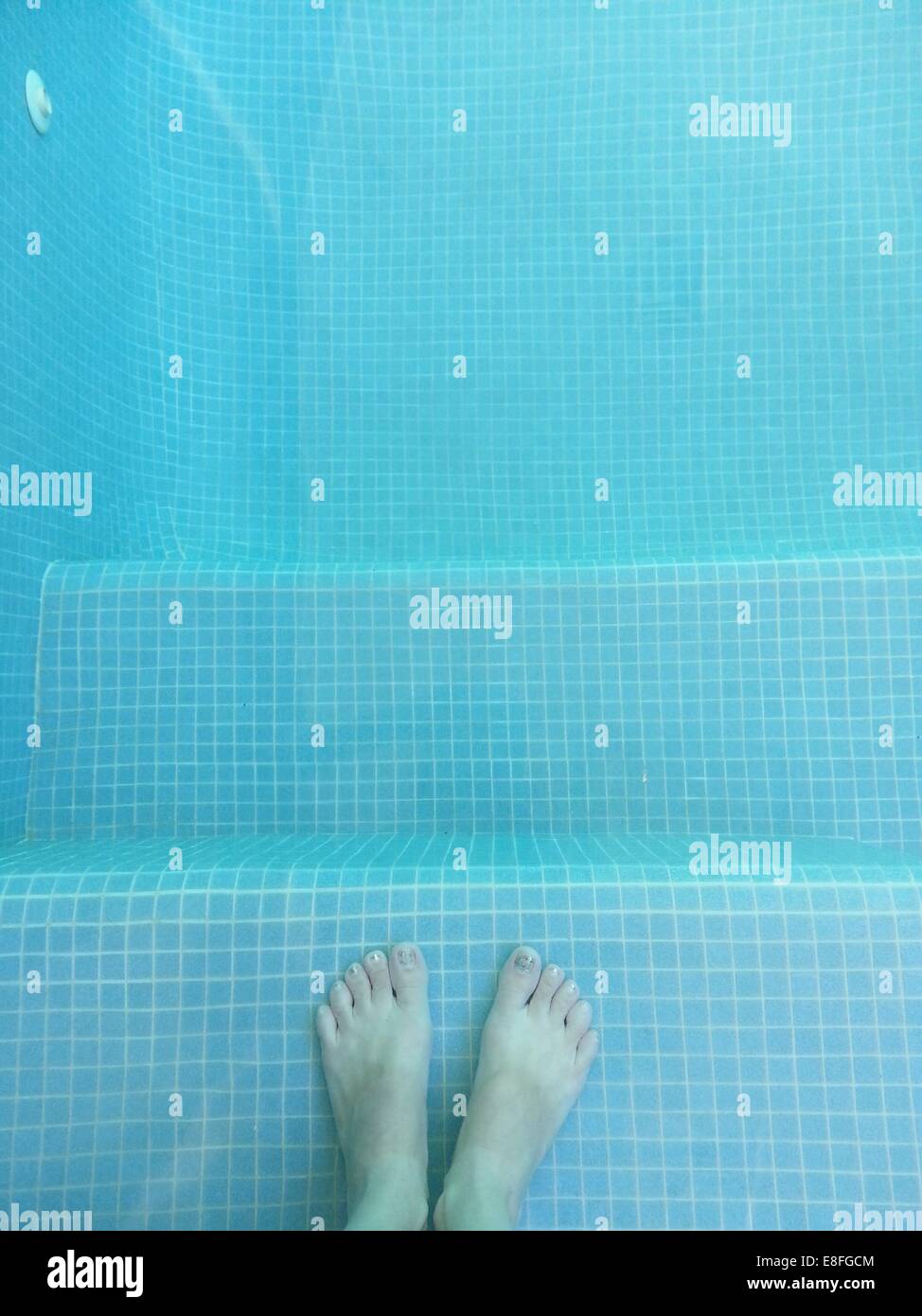 Les pieds du garçon dans la piscine Banque D'Images