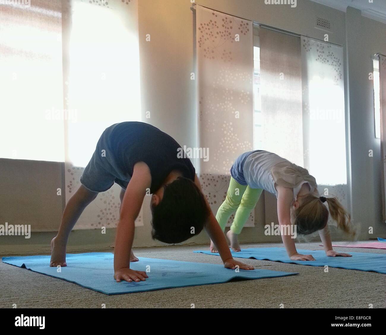 Deux enfants faisant bas yoga pose Banque D'Images
