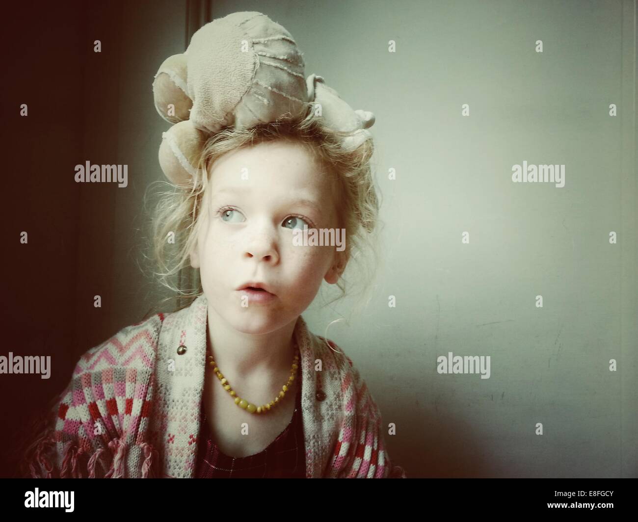 Portrait d'une fille avec un ours en peluche sur sa tête Banque D'Images