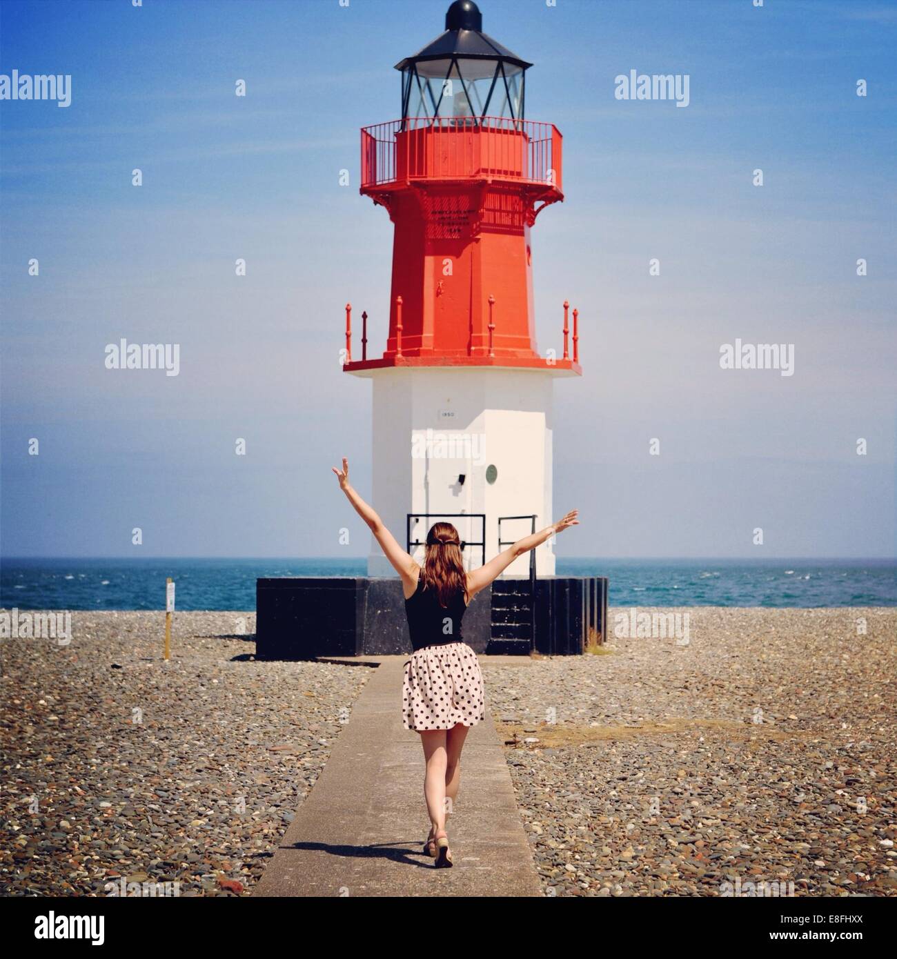 Woman standing in front of lighthouse Banque D'Images
