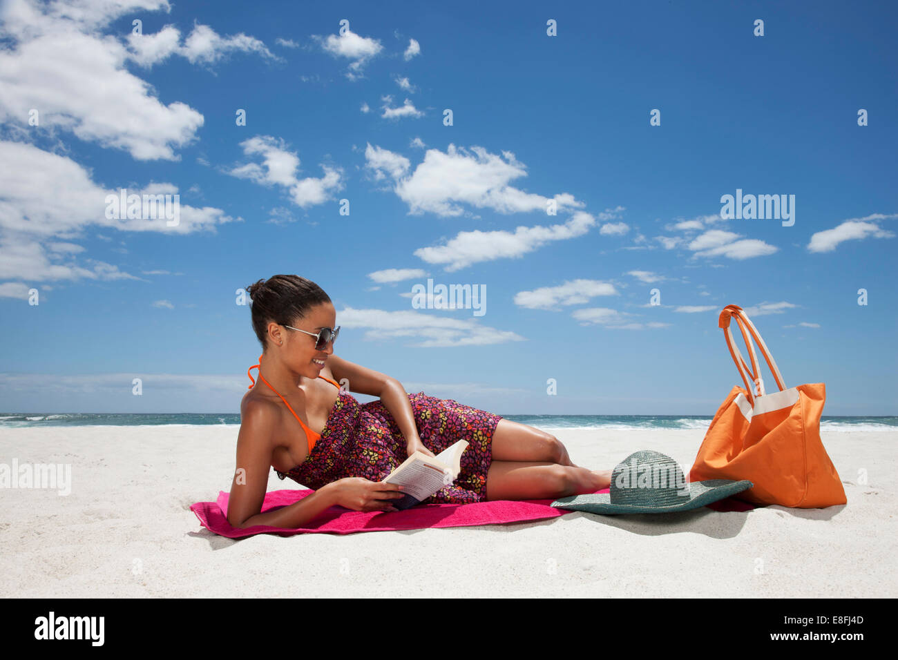 Femme couché sur la plage de lecture, le Cap, le Cap occidental, Afrique du Sud Banque D'Images