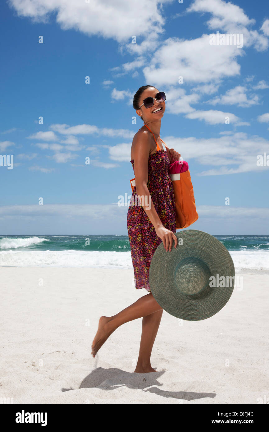 Femme souriante marchant sur la plage, le Cap, le Cap occidental, Afrique du Sud Banque D'Images