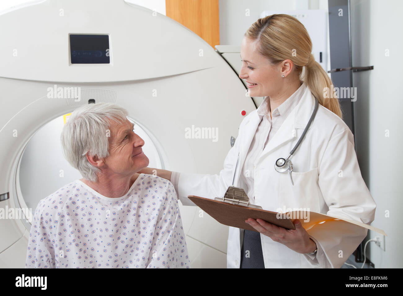 Female Doctor Talking to patient de sexe masculin à côté du scanner médical Banque D'Images