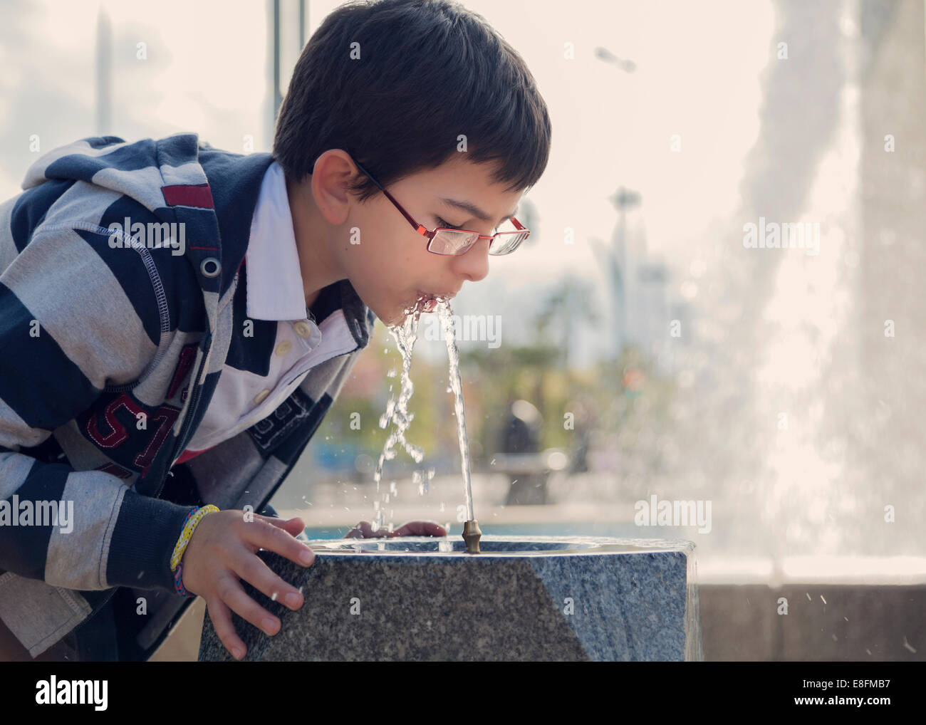 L'Espagne, Cordoue, Boy (12-13) l'eau potable de la fontaine dans park Banque D'Images