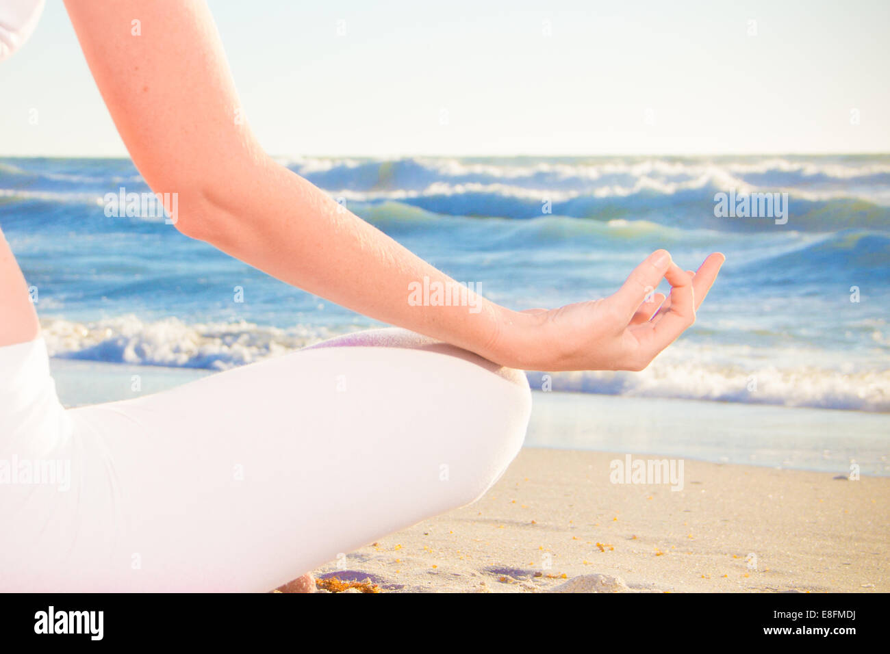 Woman practicing yoga on beach Banque D'Images