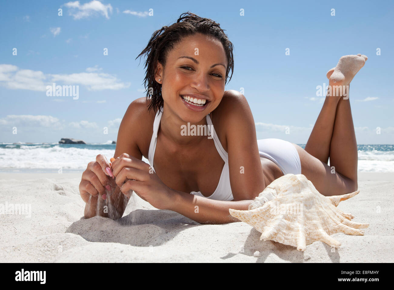 Portrait d'une femme souriante, située sur la plage, le Cap, le Cap occidental, Afrique du Sud Banque D'Images